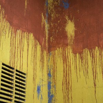 Artista: Mia. Descrição: Muro externo da cooperativa apresenta pintura em vermelho e amarelo. A pintura foi preparada pelo artista Mia para receber murais graffiti por cima.