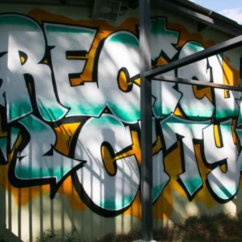 Artista: Draws. Descrição: Muro externo apresenta grafitti do nome Recicla City.