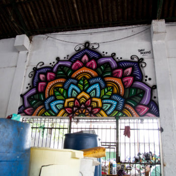 Artista: Dan Roots. Descrição: Parede interna da Cooperativa Central Tietê apresenta mural artístico de uma mandala multicolorida.