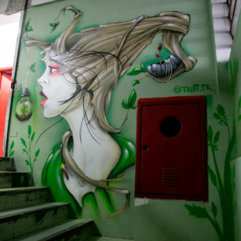 Artista: Truff TK. Descrição: Parede interna da Cooperativa Central Tietê apresenta mural artístico do rosto de uma mulher de perfil. Seus cabelos parecem troncos de árvore, simbolizando sustentabilidade e meio ambiente.