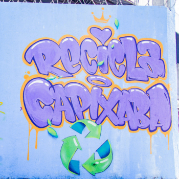 Descrição: Graffiti com fundo azul, e letras escritas em roxo com os dizeres: Recicla Capixaba.